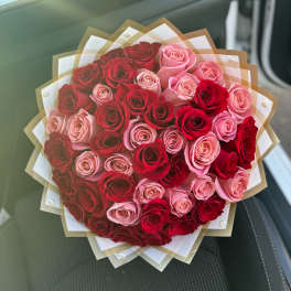 Bouquet of red and pink roses wrapped in layered paper