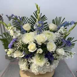 White roses and chrysanthemums with blue flowers in a low arrangement