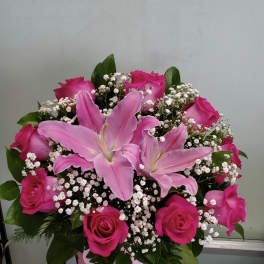 Pink lilies and roses in a pink hatbox with baby's breath