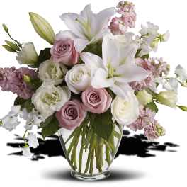 Pink and white bouquet with lilies and roses in a clear glass vase