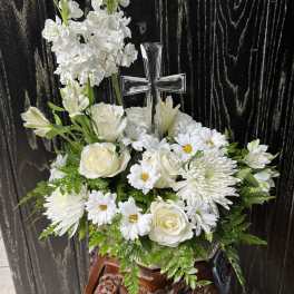 White floral arrangement with a clear cross centerpiece