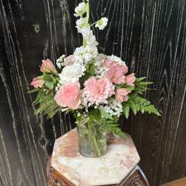 Pink and white floral arrangement in a glass vase