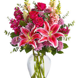 Pink lilies and roses in a clear glass vase