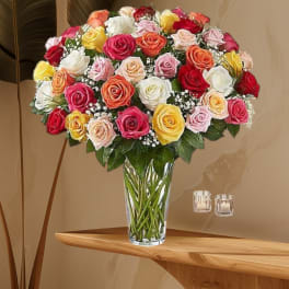 Mixed roses in a clear glass vase with baby's breath