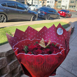 Bouquet of red roses wrapped in red paper with a ribbon