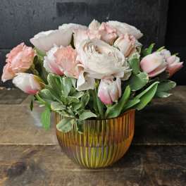 Pink and white flowers arranged in an amber glass vase