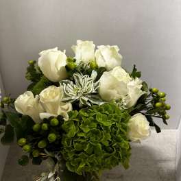 White roses and green hydrangea in a compact bouquet