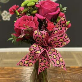 Pink rose bouquet in a glass vase with a leopard-print ribbon