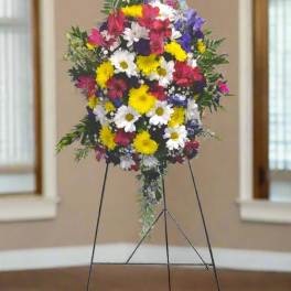 Standing floral spray with mixed bright flowers on a metal easel