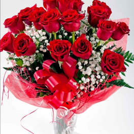 Bouquet of red roses with baby's breath in a clear glass vase