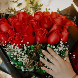 Bouquet of red roses with baby's breath in black wrap