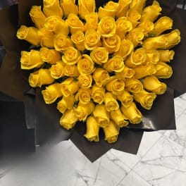 Bouquet of yellow roses wrapped in black paper