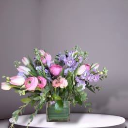 Pink and lavender bouquet in a square glass vase