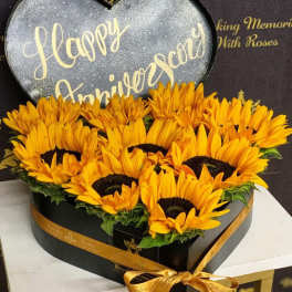 Heart-shaped box of yellow sunflowers with a Happy Anniversary sign