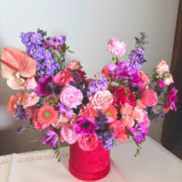 Colorful bouquet in a pink vase with pink, purple, and coral flowers
