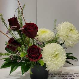 Red roses and white chrysanthemums in a black vase