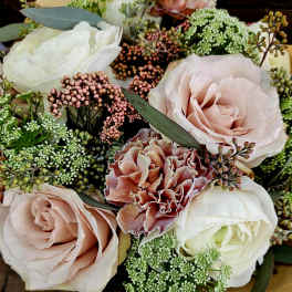 Close-up bouquet of blush roses, white blooms, and pink carnations