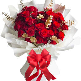 Bouquet of red roses wrapped in white paper with a red ribbon