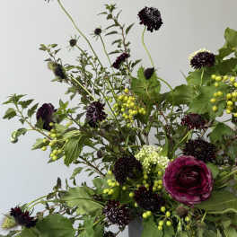 Bouquet of white and lavender roses with sunflowers and greenery