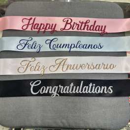 Four glittered satin ribbons with birthday and congratulations messages