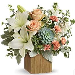 Arrangement of white lilies, peach roses, and a blue succulent in a wooden vase