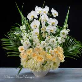 White orchids and cream roses in a low white vase