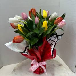 Bouquet of multicolored tulips wrapped in red and white paper