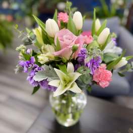 Pink roses and white tulips in a clear glass vase
