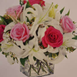 Pink and white rose bouquet in a square glass vase