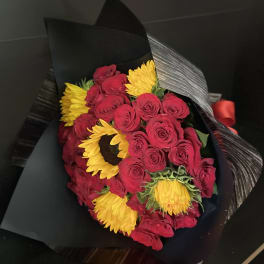 Bouquet of red roses and yellow sunflowers wrapped in black paper