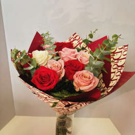 Bouquet of red, pink, and white roses in a glass vase