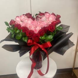 Bouquet of pink and red roses in a glass vase with a red ribbon