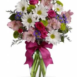 Bouquet of daisies, pink roses, and alstroemeria in a glass vase