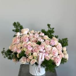 Large bouquet of pale pink roses and ranunculus in a white vase