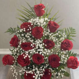Red roses arranged with baby's breath in a vase