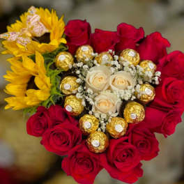 Bouquet of red and cream roses with yellow flowers and gold-wrapped chocolates