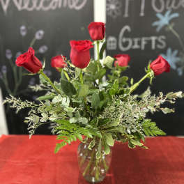 Red roses arranged in a clear glass vase