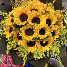 Bouquet of yellow sunflowers with dark wrapping and a decorative crown