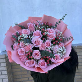 Large bouquet of pink roses and carnations wrapped in pink paper