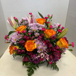 Mixed bouquet with orange roses, pink lilies, and purple daisies