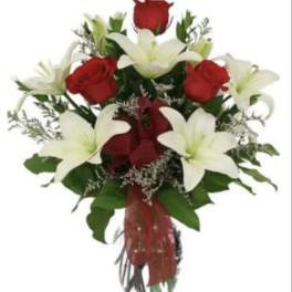 Bouquet of red roses and white lilies in a glass vase