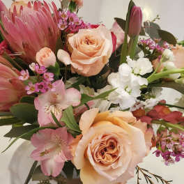 Bouquet of peach roses, pink protea, and white flowers