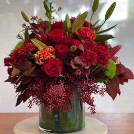 Red roses and chrysanthemums arranged in a glass vase