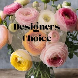 Bouquet of pink, white, and yellow ranunculus in a glass vase