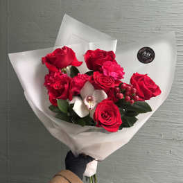 Bouquet of red roses with white orchids wrapped in white paper