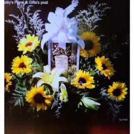 Sunflower and lily funeral spray with a white bow and framed photo