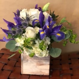 Purple irises and white roses in a wooden box
