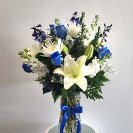 Blue and white bouquet with lilies and roses in a glass vase