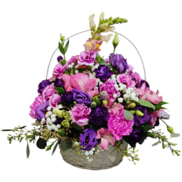 Basket arrangement of pink and purple flowers with white filler