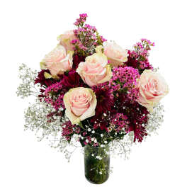 Bouquet of pale pink roses and burgundy daisies in a glass vase